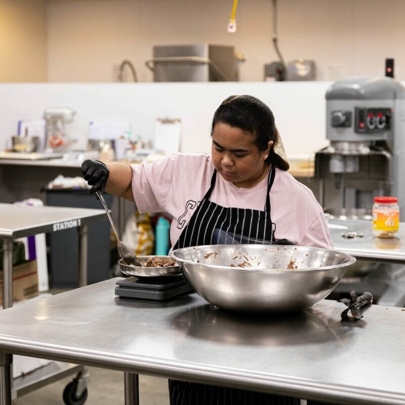 A Catapult Lakeland Kitchen incubator member weighing out portions.